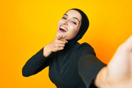 Muslim in black hijab posing fashion hand gesture isolated background. High quality photo