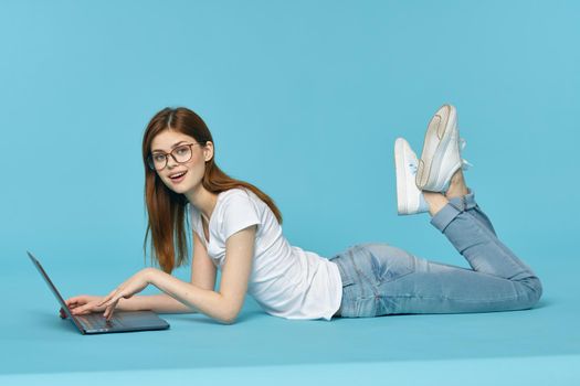 woman with laptop learning internet online education blue background. High quality photo