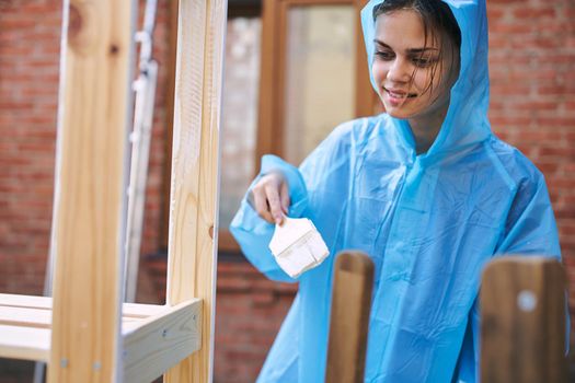 cheerful woman house painter repairing wooden structure. High quality photo