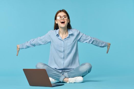 woman with laptop learning internet online education blue background. High quality photo