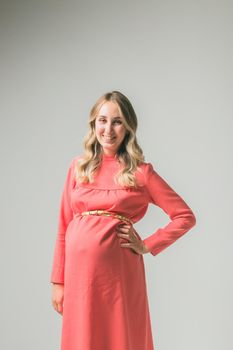 Pregnant woman on white wall background