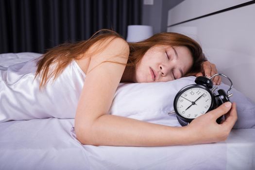 woman sleeping on the bed with clock show 6 O'clock 