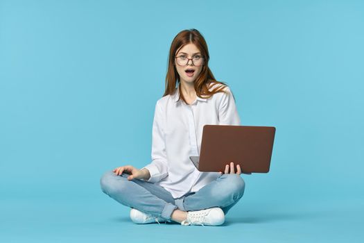 woman with laptop learning internet online education blue background. High quality photo