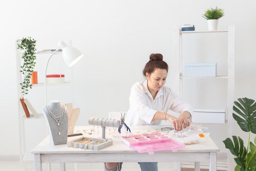 Professional jewelry designer making handmade jewelry in studio workshop. Fashion, creativity and handmade concept.