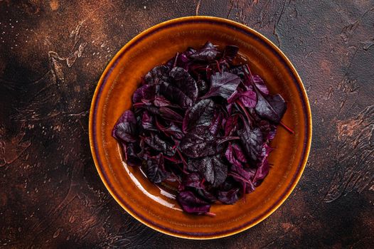 Raw Ruby or red chard salad Leafs on a rustic plate. Dark background. Top view.