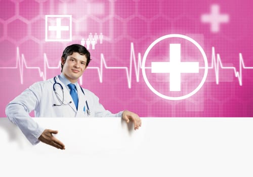 Young handsome doctor holding white blank banner. Place your text