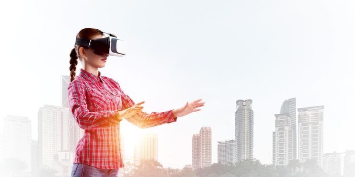 Young caucasian woman in virtual reality helmet against cityscape background
