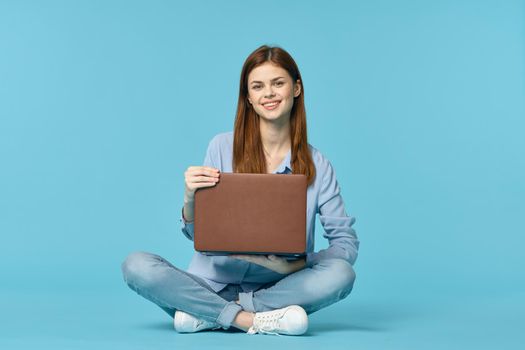 woman with laptop learning internet online education blue background. High quality photo