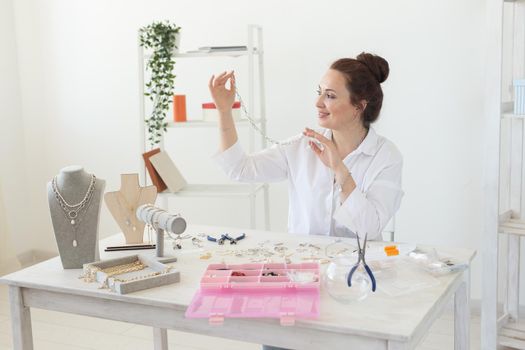 Professional jewelry designer making handmade jewelry in studio workshop. Fashion, creativity and handmade concept.