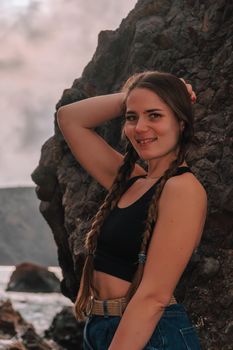 Selective focus. Happy carefree sensual woman with long hair in black swimwear posing at sunset beach. Silhouette of young beautiful playful positive woman outdoor. Summer vacation and trip concept.