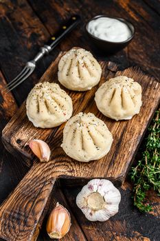Traditional manti dumplings steamed with mince meat. Dark Wooden background. Top view.