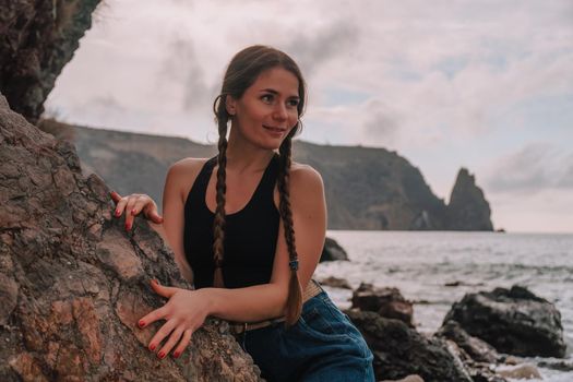 Selective focus. Happy carefree sensual woman with long hair in black swimwear posing at sunset beach. Silhouette of young beautiful playful positive woman outdoor. Summer vacation and trip concept.