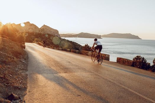 Cyclist riding on his bicycle at coastal road in the morning