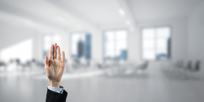 Close of businesswoman hand touching screen with palm and office at background