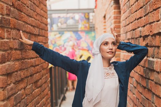 Modern muslim girl fashion with hijab.Beautiful Muslim female model wearing hijab and casual outfit posing on urban background.