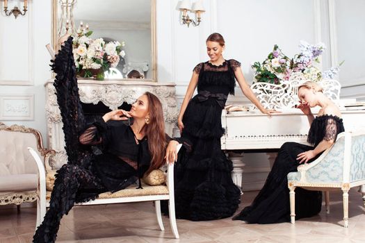 three young pretty lady in black lace fashion style dress posing in rich interior of royal hotel room, luxury lifestyle people concept close up