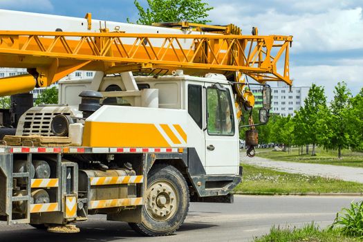 Machine industrial transportation heavy vehicle drives to a urban area on construction site.