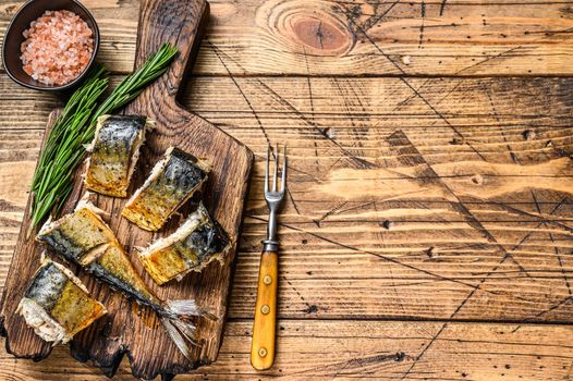 Grilled cut mackerel fish on cutting board. wooden background. Top view. Copy space.