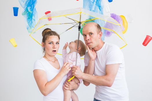 Environmental pollution, plastic recycling problem and ecology problem concept - sad family under garbage on white background