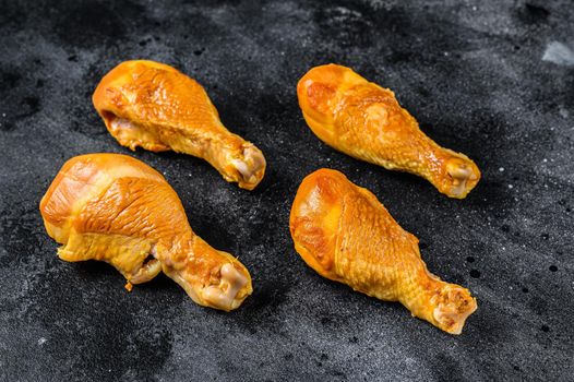 Spicy Smoked chicken leg drumsticks on a kitchen table. Black background. Top view.