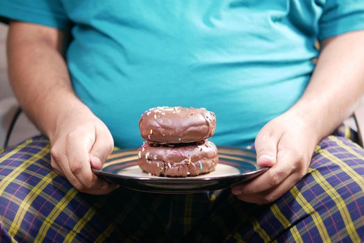 young man open his mouth eating donut , selective focus