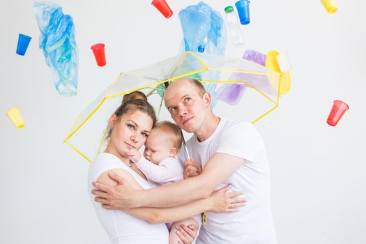 Environmental pollution, plastic recycling problem and ecology problem concept - sad family under garbage on white background