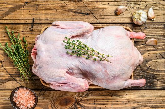 Raw young goose on wooden cutting board. wooden background. Top view.