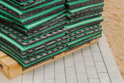 Thermal insulation or soundproof industrial building material on wooden pallet and paving slabs background, close up.