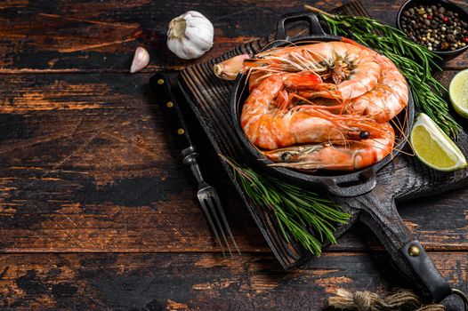 Red Tiger shrimps Prawns in a pan. Dark wooden background. Top view. Copy space.