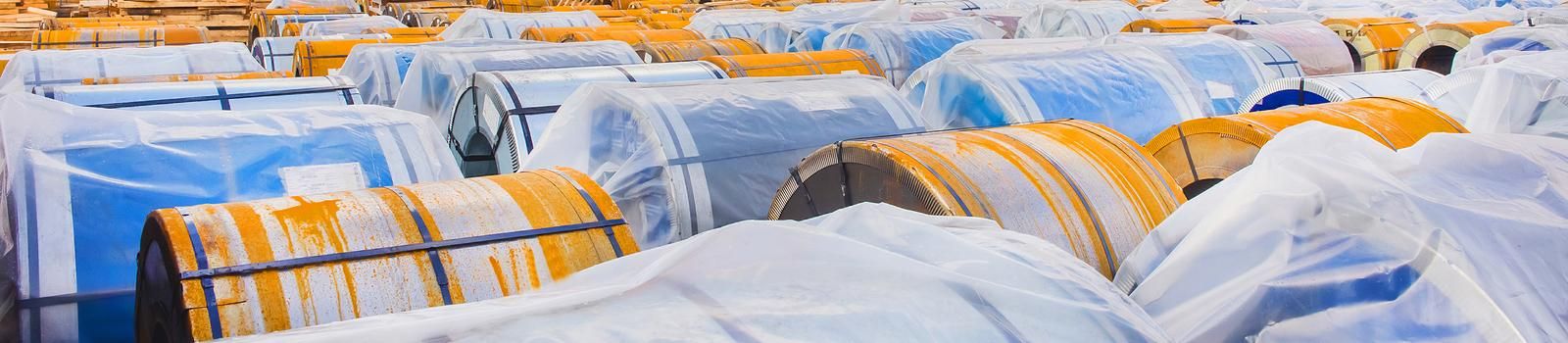 Industrial area, construction site with rusty metal packaging, steel manufacturing and storage, panoramic view, high resolution.