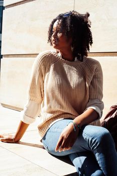 young pretty african girl posing cheerful on city background, lifestyle outdoor people concept close up