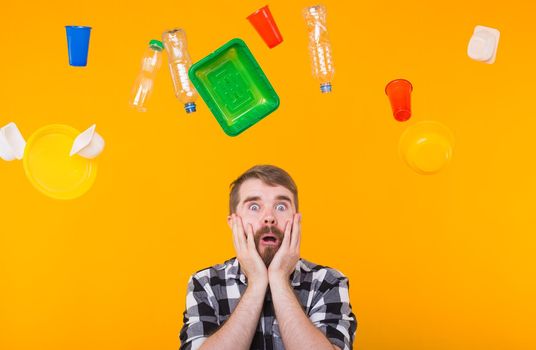 Environmental pollution, plastic recycling problem and ecology problem concept - sad man is upset because is got too much of plastic on the planet on yellow background