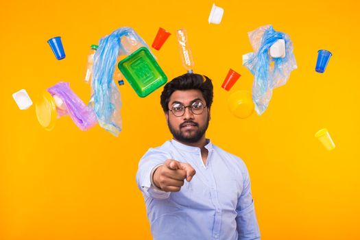 Plastic recycling problem, ecology and environmental disaster concept - Indian man point on you on yellow background.