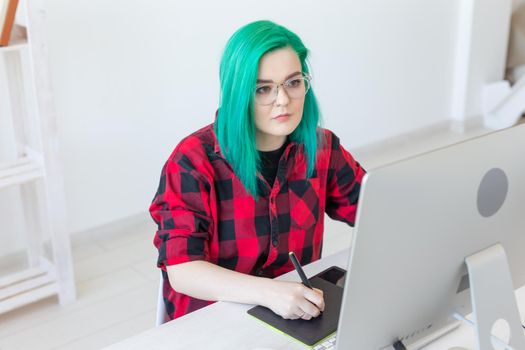 Graphic designer, people concept - Young designer female hipster with graphic tablet working in office.