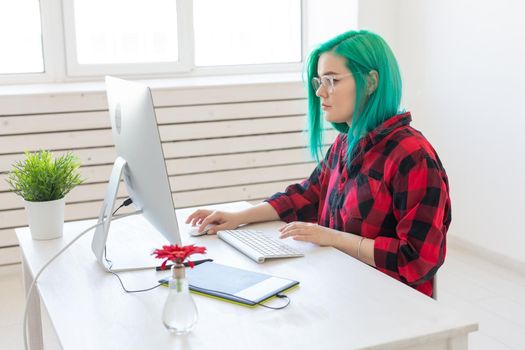 Designer, illustrator, artist and people concept - portrait of contemporary young woman with green hair using laptop and graphic tablet while working.