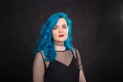 People and fashion concept - Close up portrait of woman with blue long hair over black background.