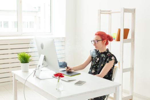 graphic designer concept - Female graphic designer working on computer while using graphic tablet at desk in the office and smoking a vape.