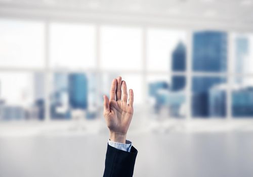 Close of businesswoman hand touching screen with palm and office at background