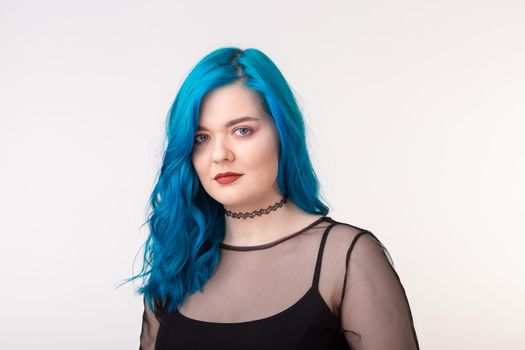 People and fashion concept - Beautiful woman with blue hair posing over white background.