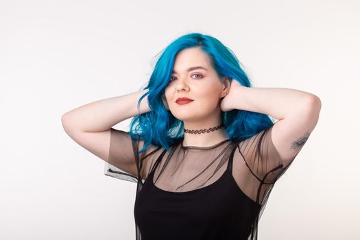 People and fashion concept - Beautiful woman with blue hair posing over white background.