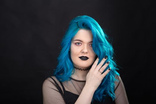 People and fashion concept - Close up portrait of woman with blue long hair over black background.