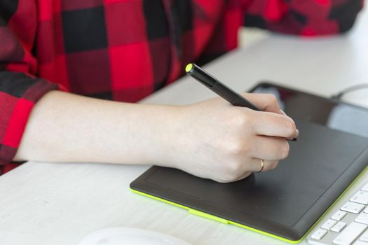 Business, designer and animator concept - close up of hand of graphic designer drawing at the tablet.