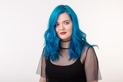 People and fashion concept - Beautiful woman with blue hair posing over white background.