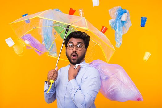 Problem of trash, plastic recycling, pollution and environmental concept - man carrying garbage bag on yellow background.