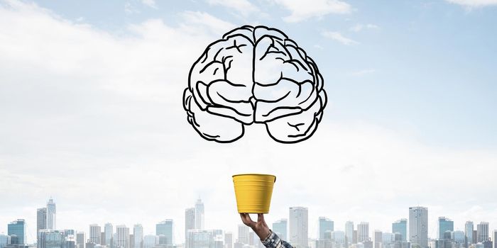 Brain drawing flying above yellow pot. Human hand holding pot with brain on modern cityscape background. Brainstorming and creative idea generation. Business education and knowledge.