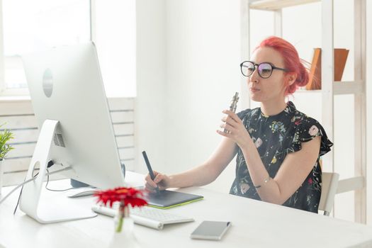 Creative, graphic designer, people concept - young creative woman smoking a vape while working in a graphic tablet.
