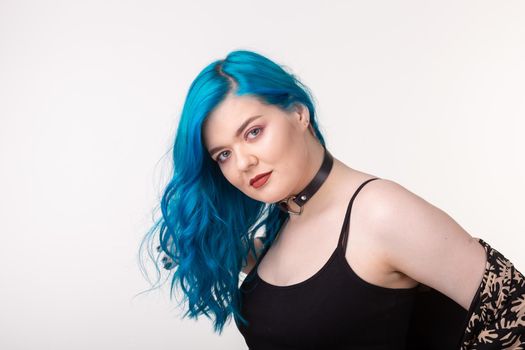 People and fashion concept - Beautiful woman with blue hair posing over white background.
