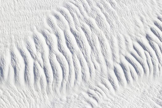 White texture of Pamukkale calcium travertine in Turkey, ribbed pattern close-up.