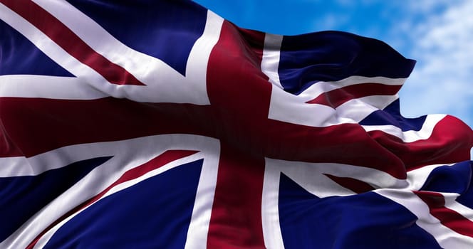 The national flag of the United Kingdom flying in the wind. Outdoors and sky in the background.