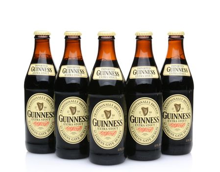 IRVINE, CA - MAY 27, 2014: Five bottles of Guinness Extra Stout on white. The Irish beer is one of the worlds most successful beer brands with annual sales over 850 million liters.